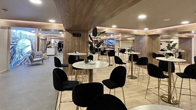 Flash club desde la entrada, sillas altas y mesas, buffet al fondo